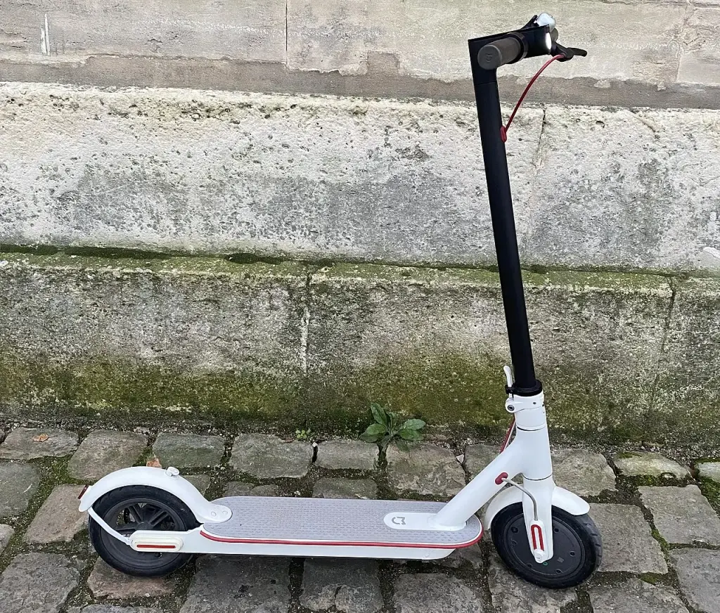 Une trottinette électrique blanche stationnée en extérieur