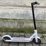 Une trottinette électrique blanche stationnée en extérieur