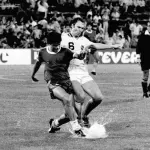 Diego Maradona et Franz Beckenbauer sur un terrain de football en 1980.