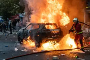 Des pompiers éteignent une voiture incendiée à Paris le 17 octobre 2026