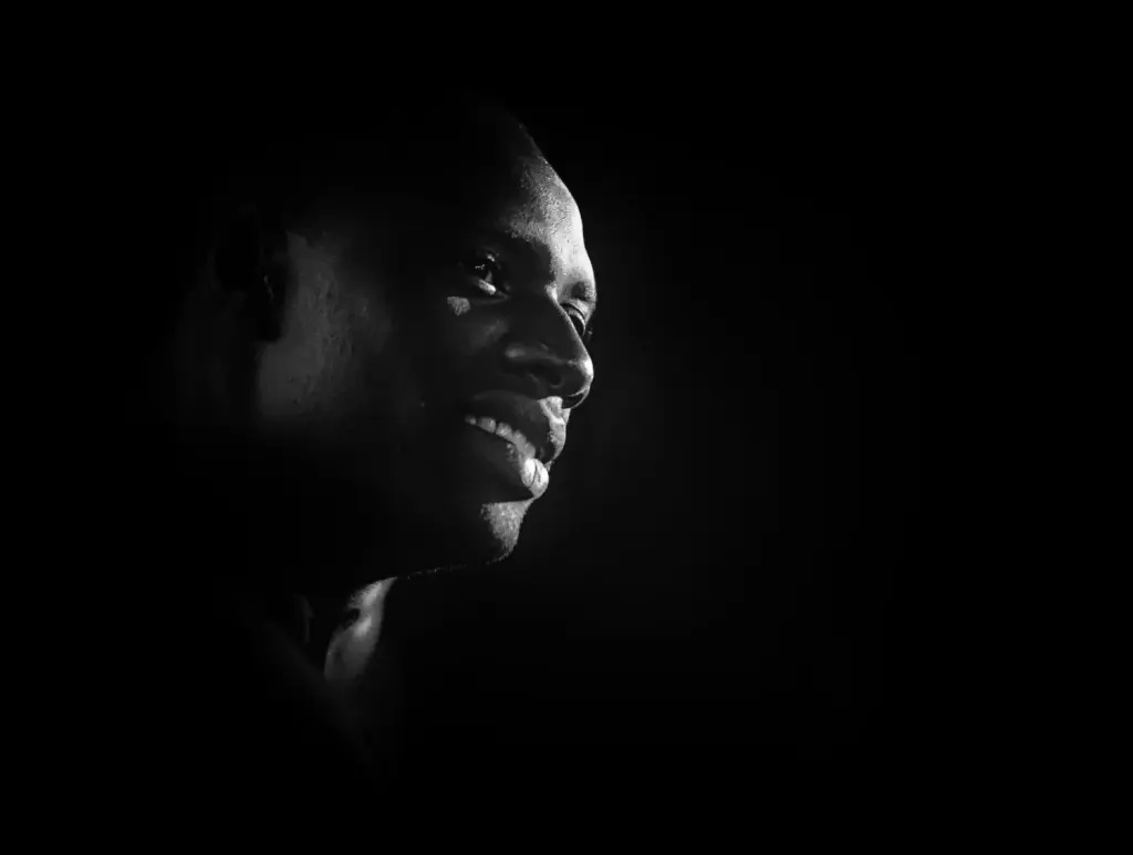 Omar Sy souriant lors d’une avant-première en 2014, photographie d’archive en noir et blanc.