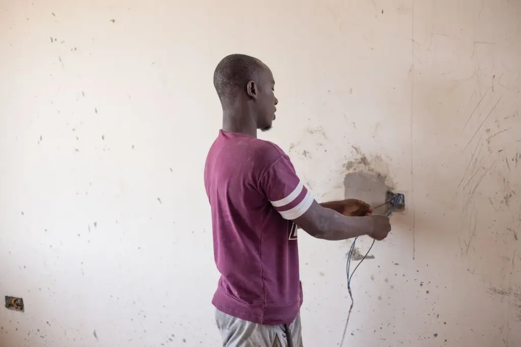 Électricien réalisant un câblage dans un logement
