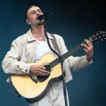 Pierre Garnier chante sur scène pendant un concert.