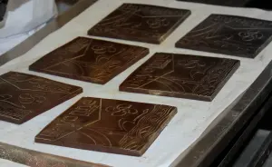 Fabrication artisanale de carrés de chocolat noir dans un atelier