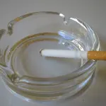 Cigarette allumée posée dans un cendrier
