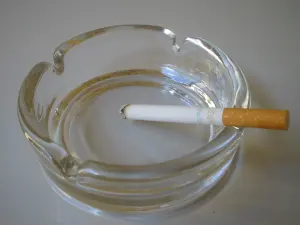 Cigarette allumée posée dans un cendrier