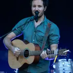 Vianney chantant sur scène avec une guitare