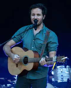 Vianney chantant sur scène avec une guitare