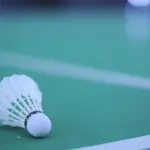 Un volant posé sur les lignes d’un terrain de badminton