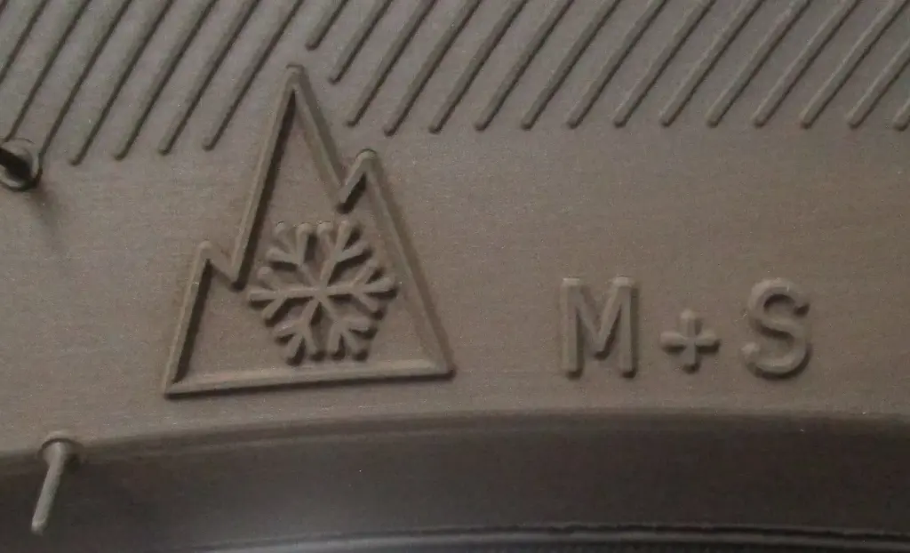Marquage alpin avec montagne et flocon sur un pneu hiver