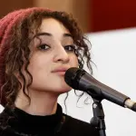 Camélia Jordana devant un microphone au Salon du livre de Paris en mars 2012, photographie d’archive