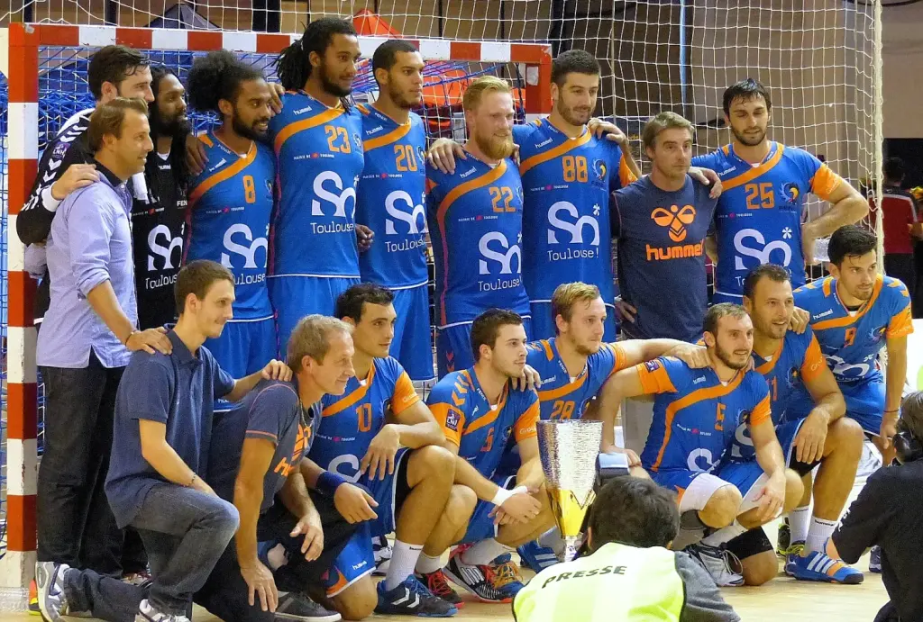 L’équipe du Fenix Toulouse en bleu et orange avec un trophée en 2014, photographie d’archive